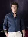 Man wearing a navy satin shirt for men with rolled-up sleeves.