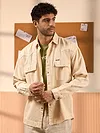 Cream denim shirt for mens with flap pockets, styled over a green t-shirt.